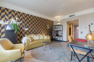a living room with a couch and a table at Leonardo Hotel Antwerp The Plaza in Antwerp