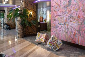 ein Zimmer mit einer farbenfrohen Wand und einer großen Vase in der Unterkunft NYX Hotel Rome by Leonardo Hotels in Rom