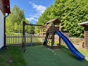 a playground with a slide and a swing at Wellness chata Kozička in Klokočov