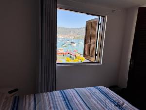 a window in a bedroom with a view of a harbor at Casa do Abrahão in Angra dos Reis +95 photos