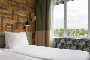 a bedroom with a bed and a window at Leonardo Hotel Vinkeveen Amsterdam in Vinkeveen