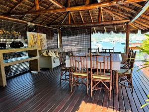 a dining room with a table and chairs on a deck at Casa do Abrahão in Angra dos Reis