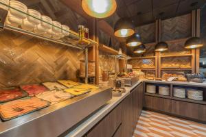 a restaurant with a buffet line with plates and dishes at Leonardo Hotel Breda City Center in Breda +32 photos