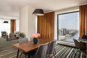 a dining room with a table and a large window at Leonardo Royal Hotel Amsterdam in Amsterdam +83 photos