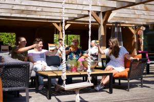 a group of people sitting around a swing at Leonardo Hotel Papendrecht in Papendrecht