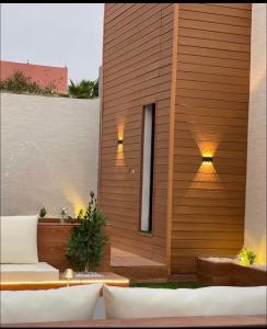a building with a wooden wall with a patio at شاليهات سمو بارك in Taif +12 photos