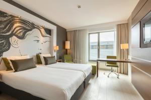 a hotel room with two beds and a desk at Leonardo Hotel Papendrecht in Papendrecht