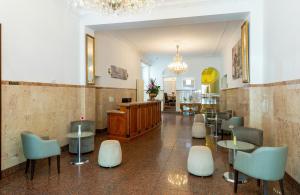a restaurant with tables and chairs in a lobby at Leonardo Hotel Berlin KU'DAMM in Berlin