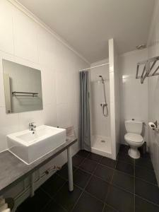 a white bathroom with a sink and a toilet at GOOD NIGHT HÔTEL By L'excess in Vierzon +28 photos