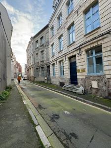 a person walking down a street next to buildings at Les Toits d'Arras in Arras