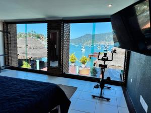 a bedroom with a view of a harbor with boats at Casa do Abrahão in Angra dos Reis