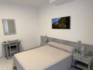 a bedroom with a bed and a table and a mirror at Hotel Beri in Llança +69 photos