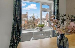 a vase of flowers on a table in front of a window at Central Upton Upon Severn 2 bedroom property sleeps 6 in Upton upon Severn