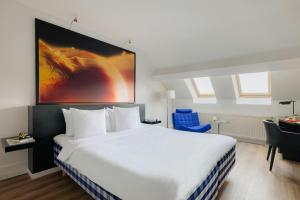 a hotel room with a large bed and a desk at Leonardo Boutique Hotel Maastricht City Center in Maastricht