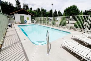 a swimming pool with chairs and a fence at Linderhof Inn in Leavenworth