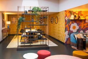 a store with colorful walls and tables and stools at Leonardo Boutique Hotel Maastricht City Center in Maastricht