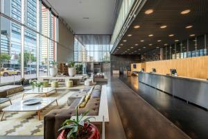a lobby with couches and tables in a building at Leonardo Royal Hotel Barcelona Forum in Barcelona