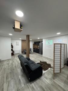 a living room with a black couch in a room at La Suite Mirebalaise in Poitiers