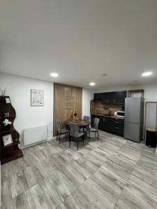 a kitchen and dining room with a table and a refrigerator at La Suite Mirebalaise in Poitiers