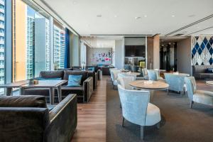 a hotel lobby with couches and tables and chairs at Leonardo Royal Hotel Barcelona Forum in Barcelona