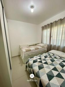 a bedroom with two beds and a checkered floor at Casa Aconchego Barra Velha/SC in Barra Velha