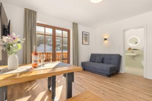 a living room with a table and a couch at Alpen Lodge Samerberg in Samerberg