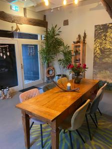 a dining room with a wooden table and chairs at 't Hof van Wespert in Westdorp