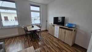a living room with a tv and a table with a tableablish at Inselglück in Malchow