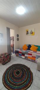 a room with two beds and a rug on the floor at Casa simples Natal Luz e FIG in Garanhuns