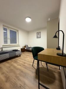 a room with two beds and a table and a bedroom at Borówkowy domek in Janik