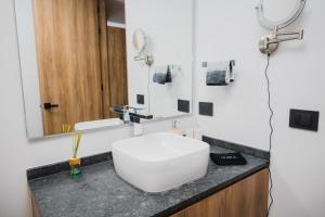 a bathroom with a white sink and a mirror at Livet Ottawa 802 in Guadalajara +92 photos