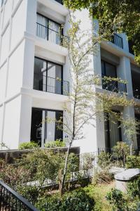 a white building with a tree in front of it at Livet Ottawa 802 in Guadalajara