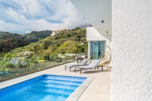 a villa with a swimming pool and a view of a hill at Half Gate Villa - Ocean View & Private Pool in Gaula