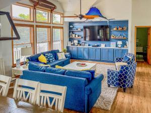 a living room with a blue couch and chairs at Raspberry Duck - Duck Landing, 525 Yds to Beach, Pool, Tiki Bar, Hot Tub, Close to Downtown in Duck