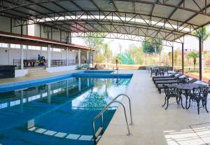 a swimming pool with tables and chairs in a building at Habitación Privada in Jacuaro