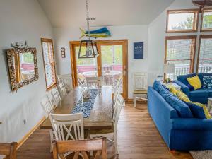 a living room with a table and a blue couch at Raspberry Duck - Duck Landing, 525 Yds to Beach, Pool, Tiki Bar, Hot Tub, Close to Downtown in Duck
