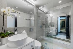 a white bathroom with a sink and a toilet at Hudson Yards Hotel in New York +52 photos