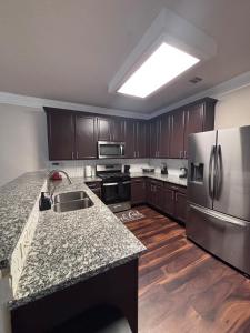 a kitchen with a stainless steel refrigerator and wooden floors at 5bd Beautiful Modern home in Spring in Spring