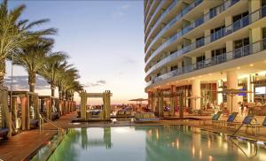 a hotel with a swimming pool and palm trees at Oceanfront Lyfe Resort in Hollywood