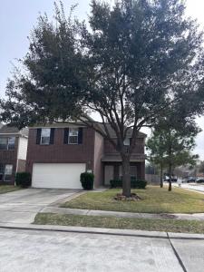 a tree in front of a house with a garage at 5bd Beautiful Modern home in Spring in Spring