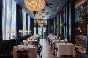 a dining room with tables and chairs and chandeliers at InterContinental Table Bay Cape Town by IHG in Cape Town