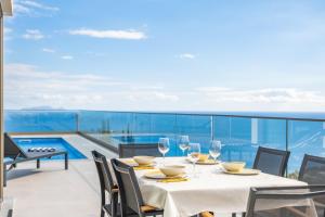 a table with wine glasses on a balcony with a view at Half Gate Villa - Ocean View & Private Pool in Gaula