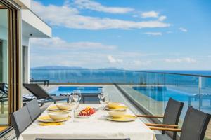 a table with wine glasses and a bowl of fruit on a balcony at Half Gate Villa - Ocean View & Private Pool in Gaula