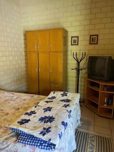 a bedroom with a bed and a tv at Sítio Ubaitaba in Boituva +16 photos