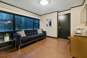 a living room with a couch and a large window at Hudson Yards Hotel in New York
