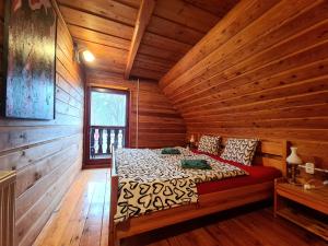 a bedroom with a bed in a log cabin at Sępia Chata dom do wynajęcia in Świeradów-Zdrój