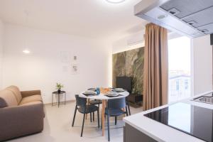 a kitchen and living room with a table and a couch at ARQO Apartments in Marcianise