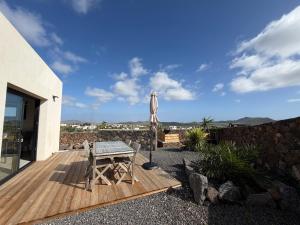 a wooden deck with a table and an umbrella at Casa Bela in Villaverde