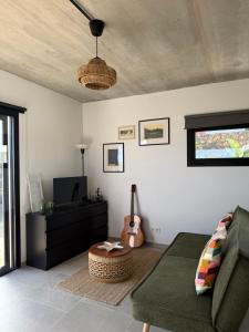 a living room with a green couch and a guitar at Casa Bela in Villaverde +4 photos