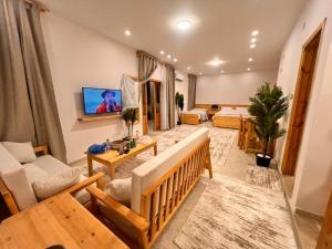 a living room with a couch and a tv at deluxe experience siwa in Siwa